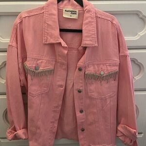 Pink denim jacket but not heavy like denim.  Silver fringe on pockets